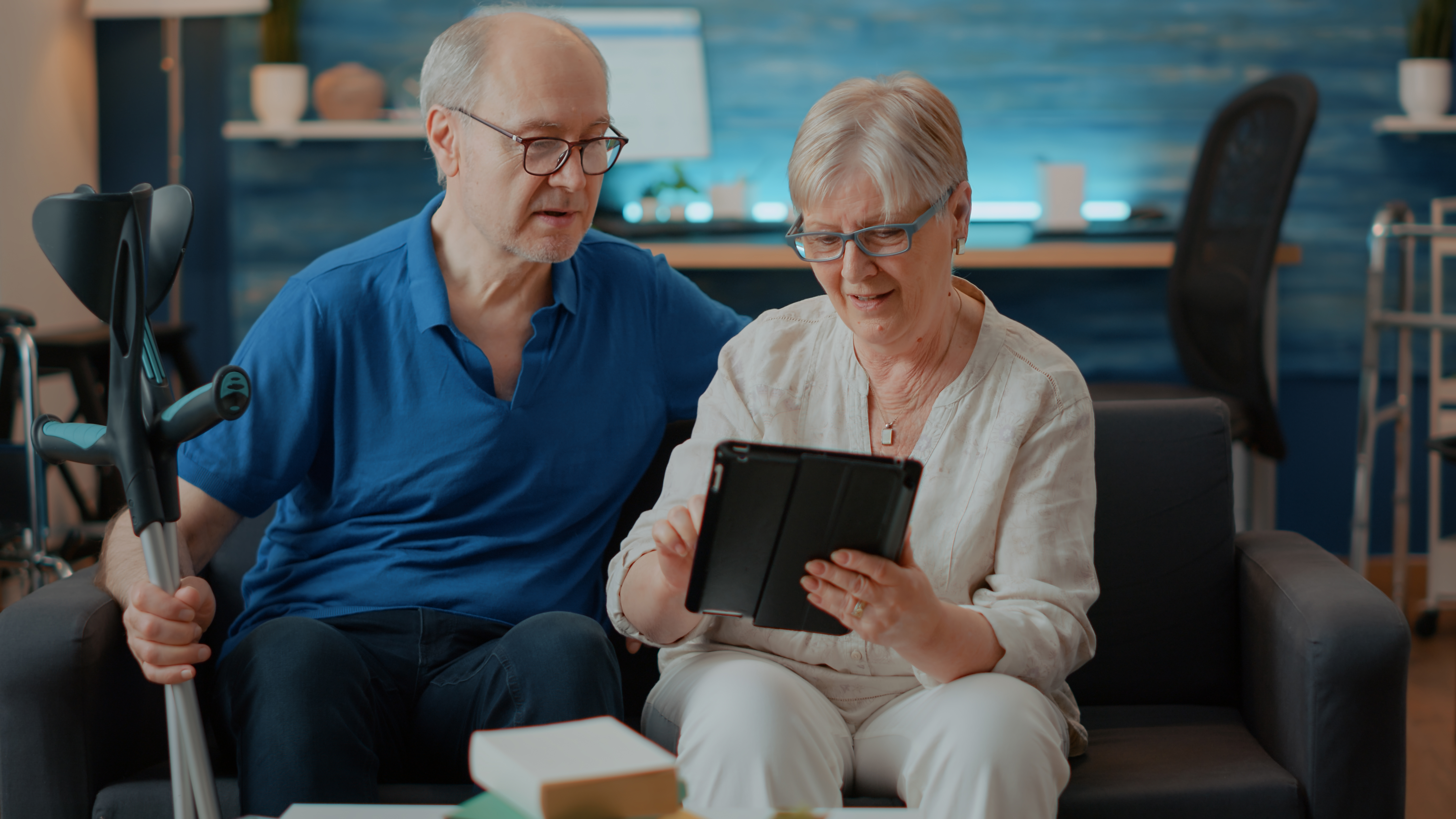 Elder couple looking at tablet screen in living room